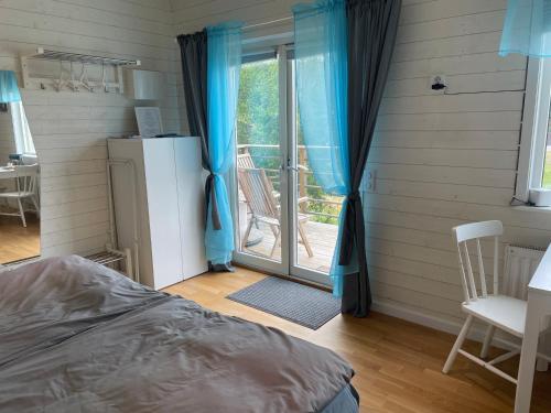 MyggenäsにあるStugaのベッドルーム1室(ベッド1台付)、スライド式ガラスドアが備わります。