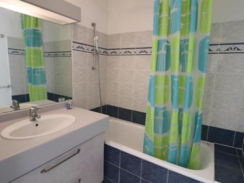 une salle de bain avec un lavabo et un rideau de douche dans l'établissement Spacieux 60m² 3⭐, terrasse piscine, proche plage - FR-1-472A-136, à Sète
