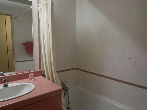 une salle de bain avec un lavabo et une baignoire dans l'établissement Appartement 2 pièces avec piscine et parking à Sète - FR-1-472A-147, à Sète
