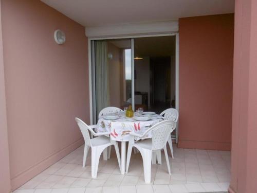 d'une table blanche avec des chaises blanches sur un balcon. dans l'établissement Rez-de-jardin à Sète: 2 pièces, piscine, parking, terrasse - FR-1-472A-129, à Sète