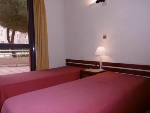 une chambre avec deux lits et une fenêtre dans l'établissement Rez-de-jardin à Sète: 2 pièces, piscine, parking, terrasse - FR-1-472A-129, à Sète