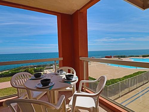 une table et des chaises sur un balcon avec vue sur l'océan dans l'établissement Studio cabine climatisé 4 pers avec piscine et parking - FR-1-472A-134, à Sète