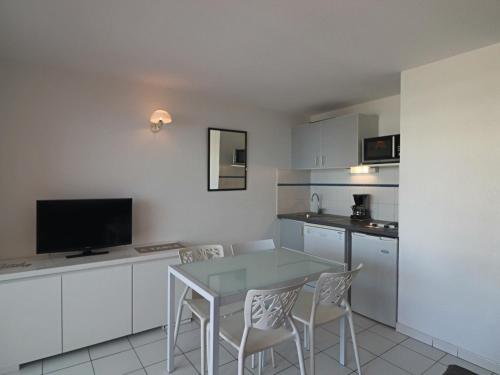 une cuisine avec une table et des chaises dans une pièce dans l'établissement Appartement 6 personnes avec terrasse et parking à Sète - FR-1-472A-165, à Sète