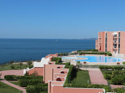 une vue d'un complexe hôtelier avec piscine et l'océan dans l'établissement Appartement 38m² avec piscine, parking, WiFi à Sète - 4 personnes, 2 pièces - FR-1-472A-139, à Sète