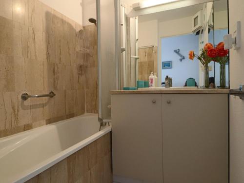 une salle de bain avec une baignoire, un lavabo et un miroir dans l'établissement Appartement 2 pièces, terrasse 14m², face plage, pour 6 personnes, classé 2* - FR-1-472A-173, à Sète