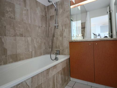 une salle de bain avec une baignoire, un lavabo et un miroir dans l'établissement 2 pièces cabine climatisé avec terrasse à Sète - FR-1-472A-166, à Sète