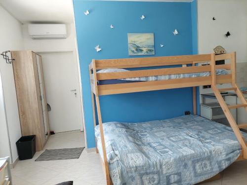 een slaapkamer met 2 stapelbedden en een blauwe muur bij Apartma Lavanda Istriana in Pobegi