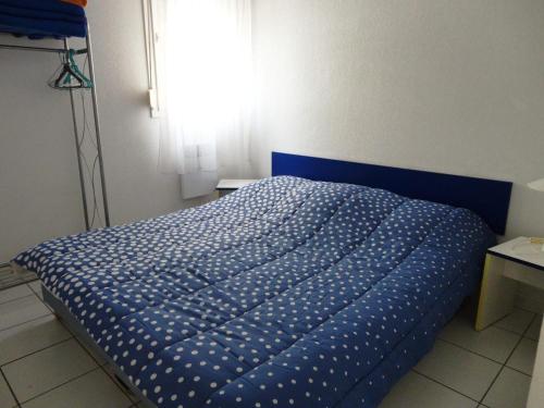 - un lit bleu dans une chambre avec fenêtre dans l'établissement Appartement 2 Pièces à Sète avec Terrasse, Piscine et Parking à 100m de la Plage - FR-1-472A-186, à Sète