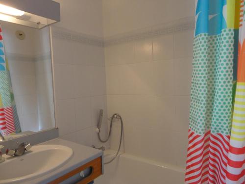 une salle de bain avec un lavabo et un rideau de douche dans l'établissement Appartement 2 Pièces à Sète avec Terrasse, Piscine et Parking à 100m de la Plage - FR-1-472A-186, à Sète