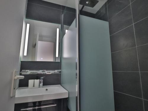 une salle de bain avec un lavabo et un miroir dans l'établissement Confortable 27m² avec WIFI, loggia et parking à Sète - FR-1-472A-205, à Sète