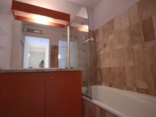 une salle de bain avec une baignoire, un lavabo et un miroir dans l'établissement Appartement Climatisé Front de Mer avec Terrasse, Piscine, et Garage Privatif à Sète - FR-1-472A-217, à Sète