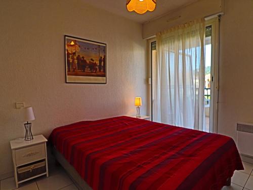 une chambre avec un lit avec une couverture rouge et une fenêtre dans l'établissement Appartement T2 climatisé avec terrasse et parking privé, à 100m de la plage à Sète - FR-1-472A-218, à Sète