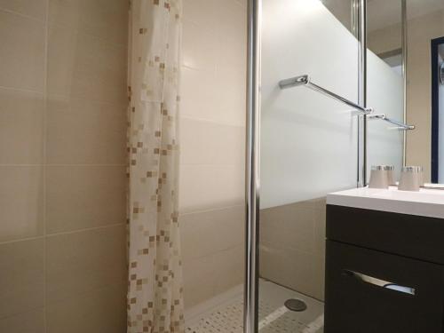 une douche avec une porte vitrée à côté d'un lavabo dans l'établissement Appartement climatisé avec terrasse et vue mer, parking - FR-1-472A-194, à Sète