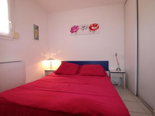 une chambre avec un lit rouge avec des oreillers rouges dans l'établissement Charmant 2 pièces cabine à Sète, vue mer, parking, terrasse - FR-1-472A-196, à Sète
