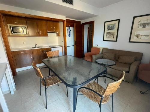 a kitchen and a living room with a table and chairs at ÁTICO CUARTA PLANTA VISTAS AL MAR in Isla Canela