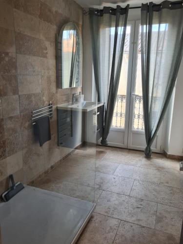 une salle de bain avec un lavabo et une fenêtre dans l'établissement Magnifique appartement avec terrasse, à Bessèges