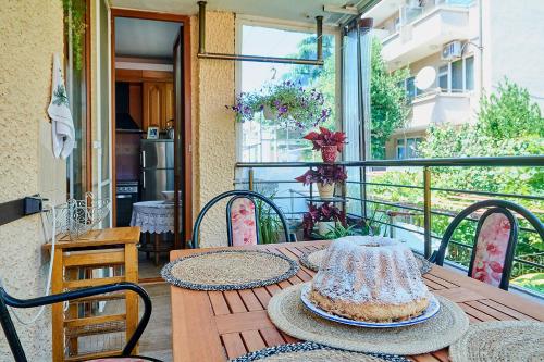 a table with a cake on top of a balcony at Apartment Dora in Pomorie