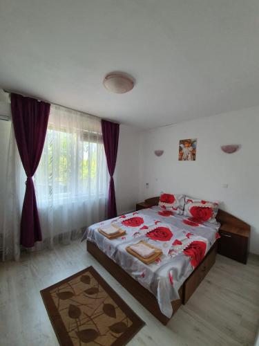 a bedroom with a bed with red roses on it at La Turturica in Corbu