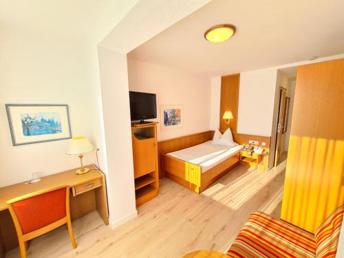 a hotel room with a bed and a tv at Thermenhotel Tannenhof - Ihr Wohlfühl-Hotel in Bad Füssing