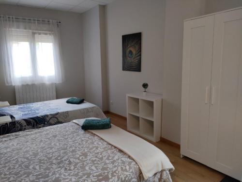 1 dormitorio con 2 camas y ventana en Apartamento en Bilbao con Wifi al lado del metro en Bilbao