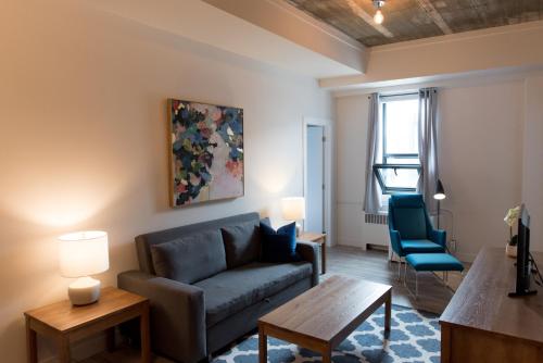 a living room with a couch and a table at Le Central in Rouyn