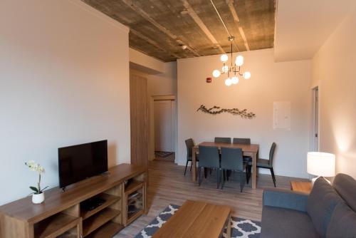 a living room and dining room with a couch and a table at Le Central in Rouyn