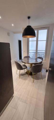un comedor con mesa y sillas en una habitación en PARIS AURIOL en París