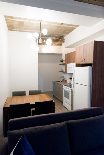 a kitchen with a table and a white refrigerator at Le Central in Rouyn