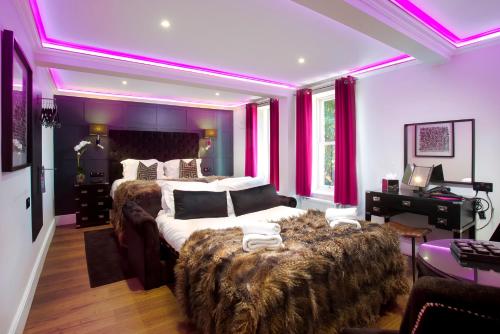 a bedroom with a large bed with purple lighting at Kotel Windermere in Windermere