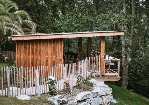 une cabane en bois dans un jardin avec une clôture dans l'établissement Hôtel Les Frères Ibarboure, à Bidart