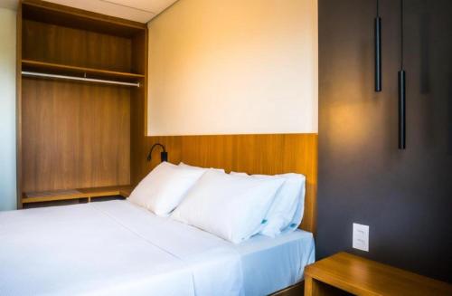 a bed with white pillows in a room at Salinas Premium Resort in Salinópolis