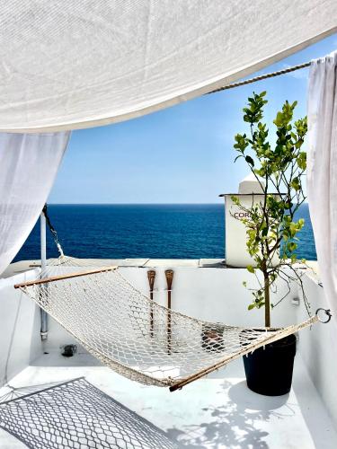 un balcón con hamaca y vistas al océano en Corallini Luxury Apartments - Bokè Apartment, en Cervo
