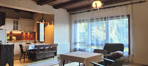 a kitchen and dining room with a table and a window at Domek na Porąbkach z kominkiem in Międzybrodzie Żywieckie