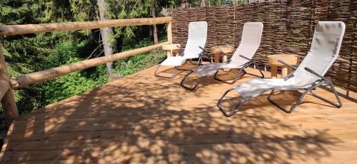 a group of chairs sitting on top of a deck at Zagroda Krowiarki Chochołów in Chochołów