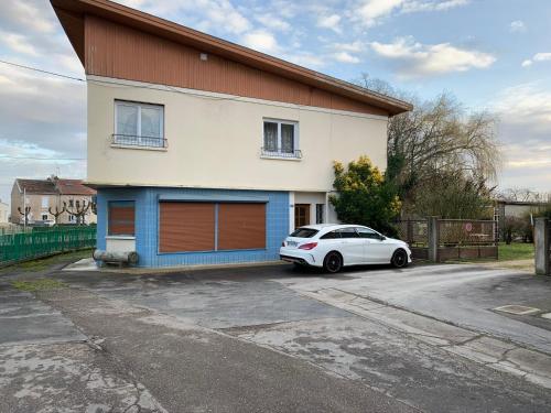 een witte auto geparkeerd voor een huis bij Appartement dans maison avec cour et parc in Fresnes-en-Woëvre