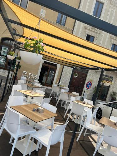a restaurant with white chairs and tables and awnings at Piazza del Mercato in LʼAquila