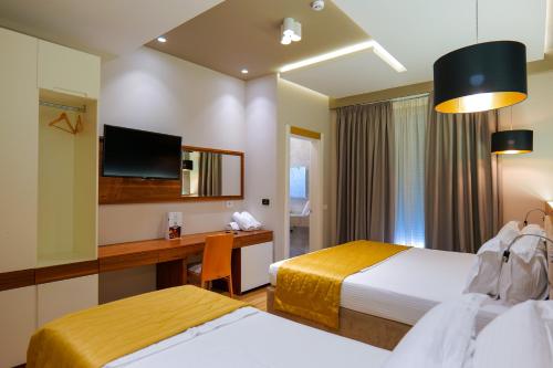 a hotel room with two beds and a desk at LORD Hotel in Tirana