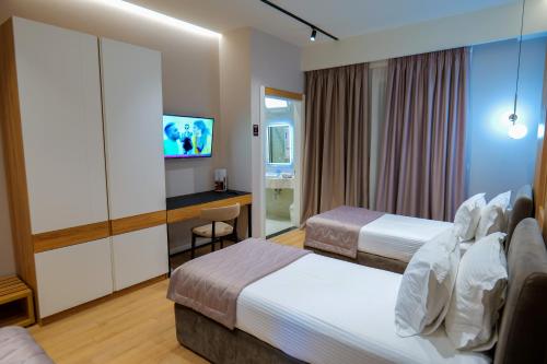 a hotel room with two beds and a television at LORD Hotel in Tirana