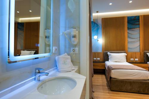 a bathroom with a tub and a sink and a bed at LORD Hotel in Tirana