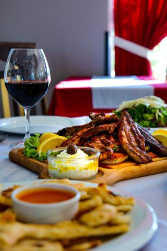 a table with a plate of food and a glass of wine at LORD Hotel in Tirana