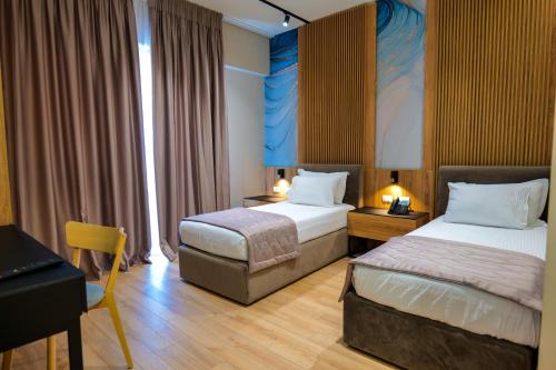 a hotel room with two beds and a desk at LORD Hotel in Tirana