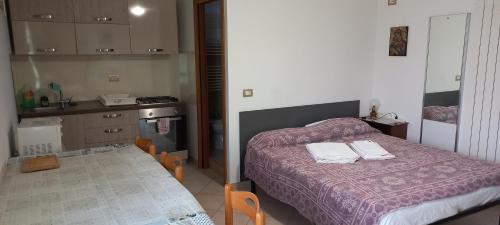 una piccola camera con letto e cucina di Casa Corso Umberto 244 piano 3° a Bernalda