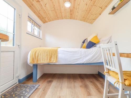 a small bedroom with a bed and a wooden ceiling at Sunflower in Redruth