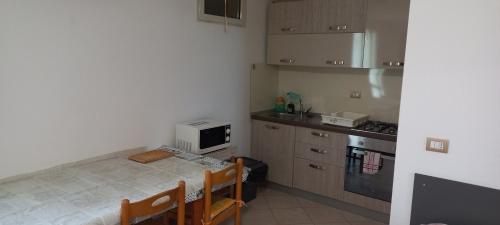 una piccola cucina con tavolo e forno a microonde di Casa Corso Umberto 244 piano 3° a Bernalda