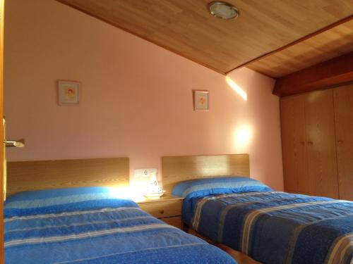 2 Betten nebeneinander in einem Zimmer in der Unterkunft La Ontina in La Puebla de Valverde