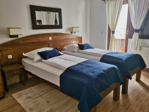 two beds in a bedroom with blue sheets at Green Garden Plitvice lakes in Plitvica selo