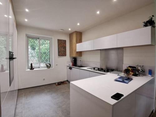 une cuisine avec des placards blancs et un comptoir blanc dans l'établissement Bestouan - 3 Chambres - Clim - Spacieux, à Cassis