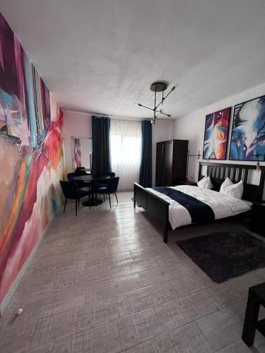 a bedroom with a bed and a table with chairs at Cabana B2 langa strandul Banffy in Topliţa