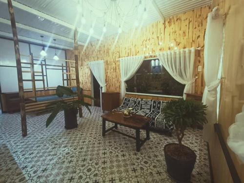 ein Wohnzimmer mit einem Sofa und einem Tisch in der Unterkunft MOre Home - Ngôi nhà nghĩ dưỡng tại Đà Lạt in Da Lat