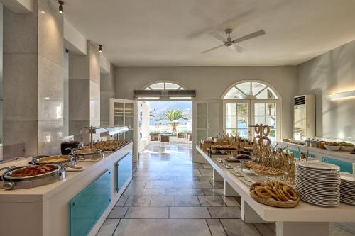 a large kitchen with a buffet line with food at Ios Palace Hotel & Spa in Mylopotas